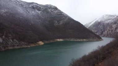 Yukarıdan insansız hava aracıyla çarpıcı bir dağ ve nehir manzarası atışı. Temiz gökyüzü, zirvelerde sis ve yeşil su, kameranın yavaş hareketi, Doğu Avrupa 'nın güzel doğası..