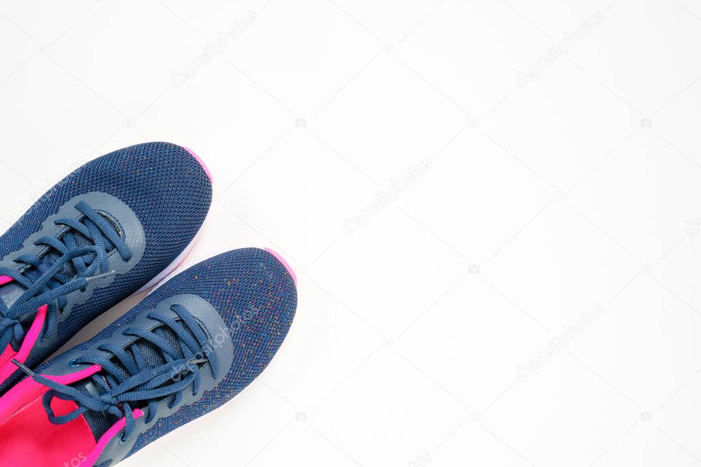 Top view of gray sneakers with crimson inside, setting on left bottom corner of the shoot. Studio, isolated, white background with copy space.