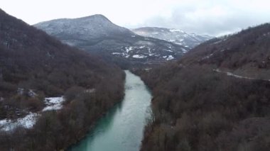 Orman dağlarıyla göz kamaştırıcı bir manzara. Altında yeşil su olan vadi ve nehir. Yukarıdan insansız hava aracı ile inanılmaz bir üst görüntü, yavaş hareket, dur ve geri dön.
