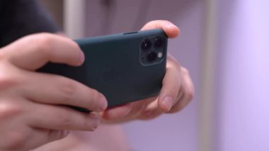 1 Mayıs 2020, Rostov-on-Don, Rusya: İnsan eli Apple iPhone 11 Pro gece yarısı yeşil renkli arka tarafında üç kamera ve fotoğraf ya da video çekimi.
