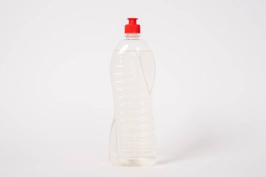 Beyaz arka planda duran şeffaf sıvı veya jel içeren plastik şişe.