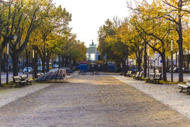 Altında der Linden Bulvarı üzerinde onarın. Sarı yapraklar, ağaç ve boş banklar. Boulevard Brandenburg Kapısı sonunda. Berlin, Almanya .