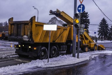 Makine kar sokak ve yükleme kar bir kamyona kürekler. Turuncu makineleri, kar temizleyiciler, trafik ışıkları yakın. Moscow, Rusya Federasyonu .