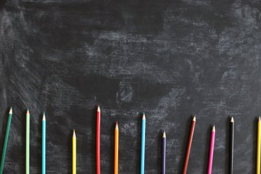 Siyah tebeşir lezin doku düz farklı renk kalemler serilmiş okul arka plan geri. Üstte görüntü.