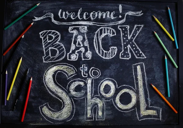 Обратно в школу с выложенными плоскими разноцветными карандашами на текстуре черной доски. Вид сверху . — стоковое фото