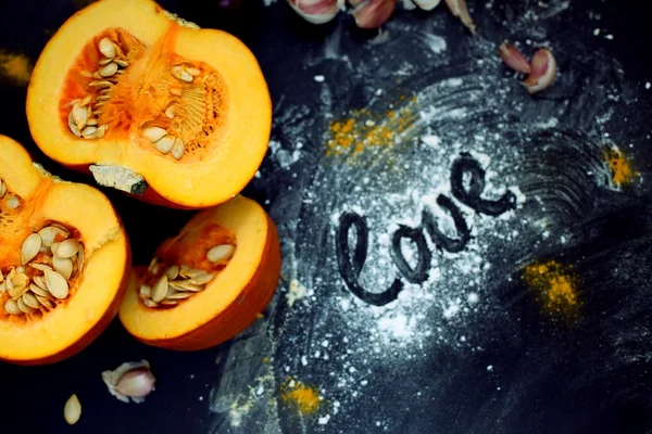 Fresh pumpkin slice on a black wooden table with flour texture. Autumn cooking background. Healthy eating. Top view. — Stock Image Fresh pumpkin slice on a black wooden table with flour texture. Autumn cooking background. Healthy eating. Top view. Royalty Free Stock Images