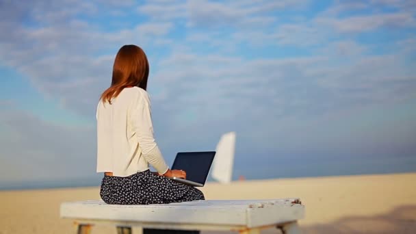 Jovem Com Laptop Sentado Banco Madeira Fundo Praia — Vídeo de Stock