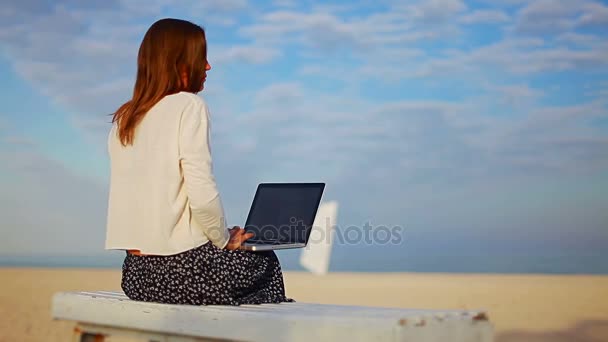 Vrouw wacht op het downloaden van bestanden op laptop tegen blauwe hemel — Stockvideo
