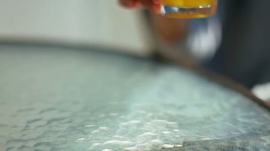 Kız portakal suyu bir bardak masanın üzerine koyar.