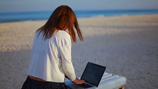 使用一个文本编辑器在度假期间在海边的年轻女士 — 图库视频影像