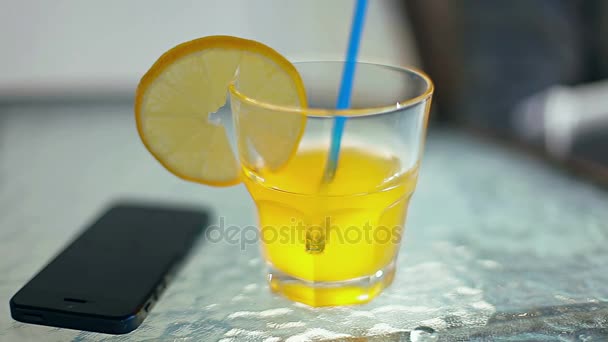 Meisje giet oranje koolzuurhoudende drank in een cocktail op tafel — Stockvideo