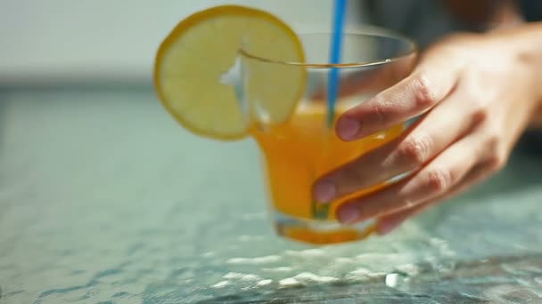 Female hands put on the table a glass with lemon and cocktail phone — Stock Video