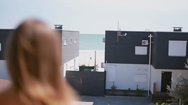 Hermosa dama mirando las casas de playa de verano — Vídeo de stock