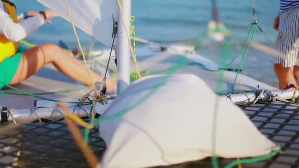 Mädchen sitzt auf dem Bord des Segel-Katamarans — Stockvideo