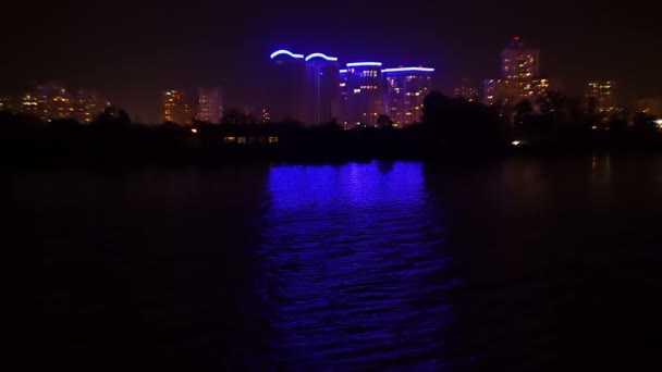 Вид на нічне місто з річки, освітлення житлових кварталів — стокове відео