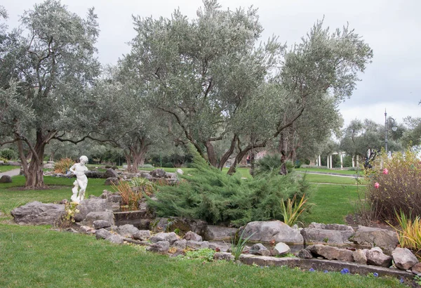 橄榄树和古代雕塑充满异国情调的公园 — 图库照片