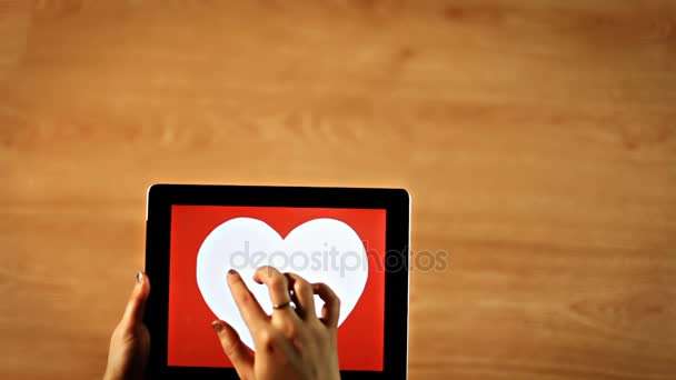 Люблю каллиграфию. Женщина пишет тонкий курсив внутри белого сердца на планшете — стоковое видео