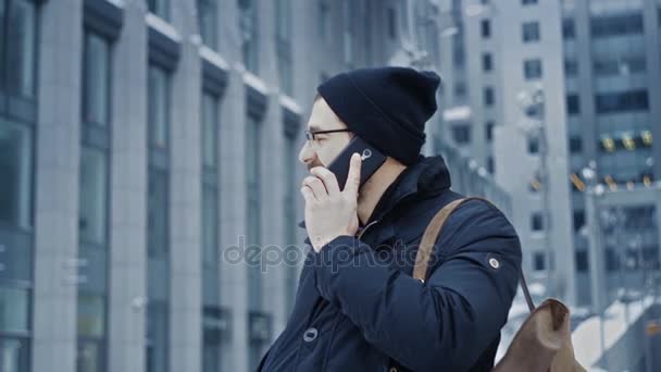 Hombre hipster hablando por teléfono en frente del centro de oficina — Vídeos de Stock