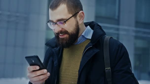 Hombre usando teléfono inteligente sonriendo — Vídeos de Stock