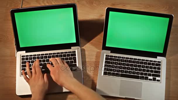 Hombre de vista superior escribiendo usando dos computadoras portátiles — Vídeo de stock