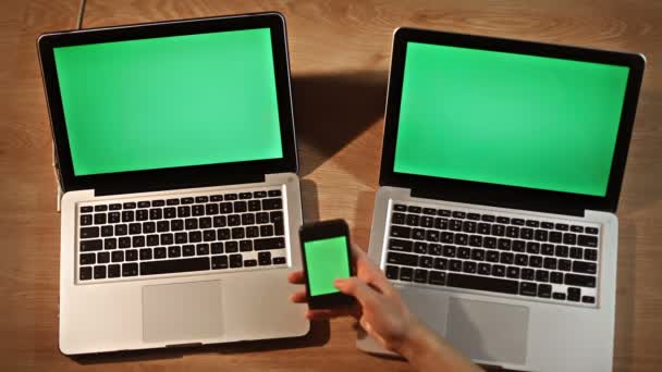 Mann mit Smartphone vor zwei Laptops — Stockvideo