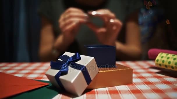 Feminino colocando um anel de prata em uma pequena caixa de presente secreta azul — Vídeo de Stock