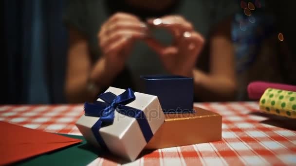 Donna che mette un anello d'argento in una piccola scatola regalo segreta blu — Video Stock