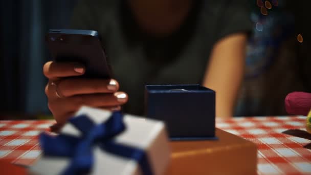 Közelről nő használ smartphone közelében egy kis kék titkos jelen box — Stock videók