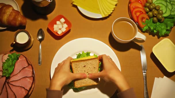 Vue de dessus femelle prendre une bouchée du sandwich pour le petit déjeuner 