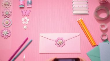 Üstten Görünüm kız bir fotoğraf şenlikli pembe zarf Smartphone'da yapma
