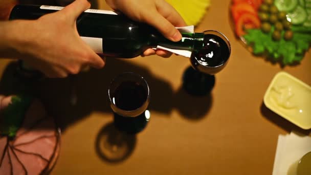 Vista dall'alto mani maschili versando vino in bicchieri femminile e maschile prendendo bicchieri — Video Stock