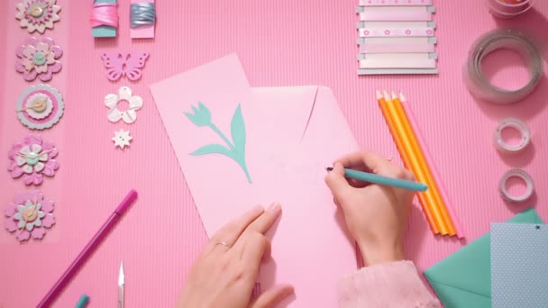 Top View menina escrevendo feliz aniversário no cartão postal scrapbook em rosa — Vídeo de Stock