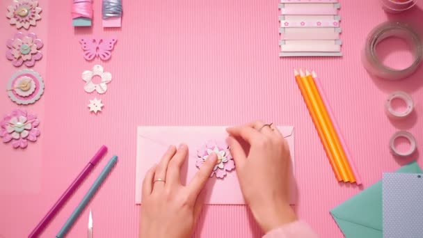 Vue de dessus fille fermeture enveloppe festive avec fleur décorative en rose — Video