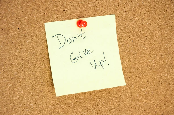 Paper note written with DONT GIVE UP inscription on cork board — Stock Photo, Image