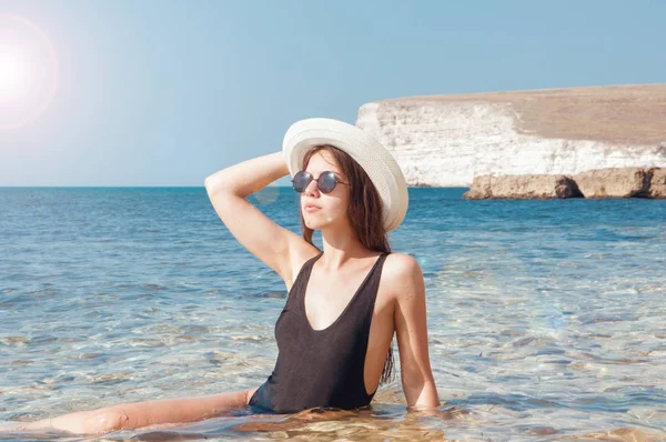 Chica en bikini, gafas y sombrero en agua de mar clara — Foto de Stock