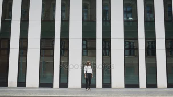 Female standing on the street of Berlin with background of modern architecture — Stock Video