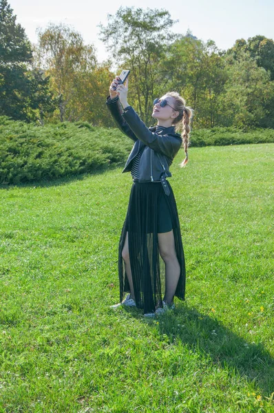 Güzel sarışın kız bir yeşil çim zemin üzerinde duruyor ve yapmak