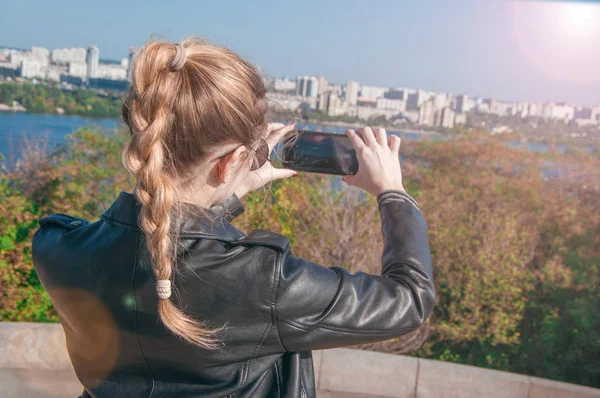 Hermosa chica rubia haciendo fotos de la ciudad en un teléfono inteligente — Foto de Stock