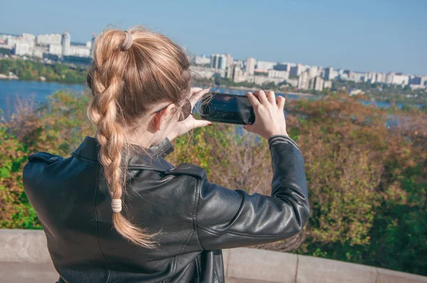 Hermosa chica rubia haciendo fotos de la ciudad en un teléfono inteligente — Foto de Stock