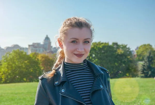 Güzel sarışın kız standları ve yeşil çim backgr gülümser