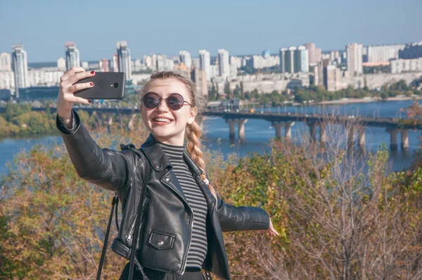 Güzel sarışın kız şehir ve m arka plan üzerinde duruyor