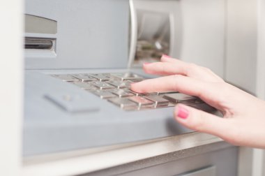 Bankacılık makine kullanan kadın. Yakın çekim. Parola sayı tuşuna basarak Atm makine üzerinde parmak.