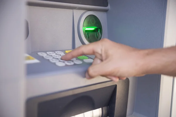 Man's using the ATM machine.