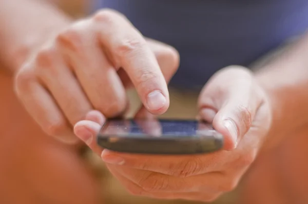 Jonge man zit in het park en het texting een bericht — Stockfoto