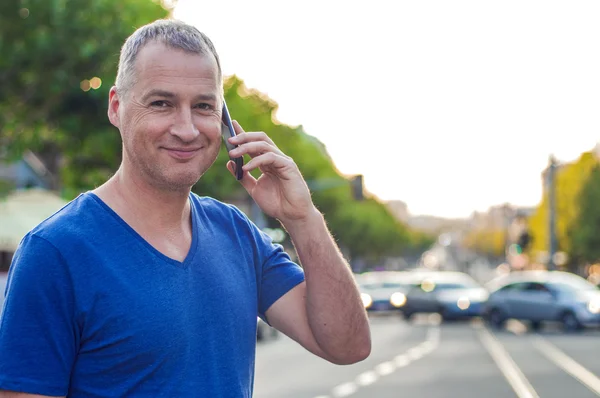 Close-up van portret van gelukkig lachend veertig jaar oude blanke man praten op een mobiele telefoon buiten — Stockfoto