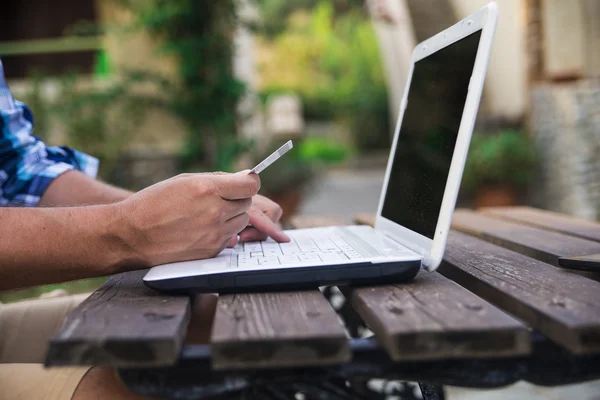 stock image Handsome man shopping online with a credit card and a laptop