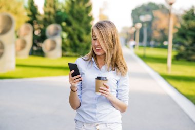 Kendine güvenen kadınlar, iş molası sırasında şirket koridorda yürürken Finans Haberler hakkında bilgi okuma başarılı işkadını iken ona müşteri kısa mesaj yazma sekreteriyle ofisine gidiyor