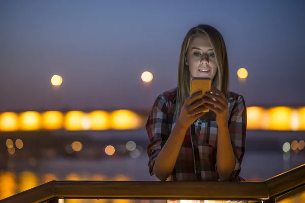 Красивая молодая женщина разговаривает по мобильному телефону в ночном городе . — стоковое фото
