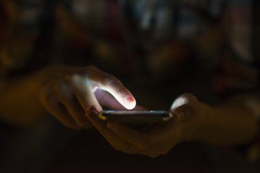 Onun cep telefonu, şehir manzarası gece açık renkli kullanan kadın