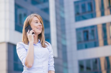 açık havada, modern binanın arka plan olarak telefonla konuşurken iş kadın portresi.